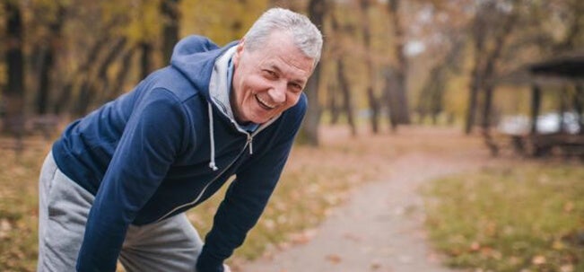 An older man taking a rest whilst walking