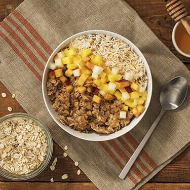 A bowl of overnight oats next to a spoon 