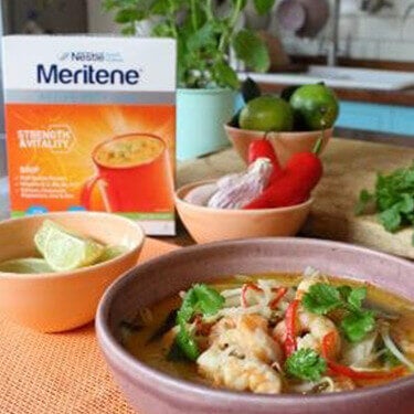 A bowl of seafood in front of a Meritene Strength & Vitality sachet